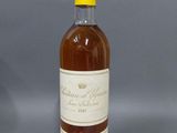 une bouteille de vin posée sur une table devant un fond gris