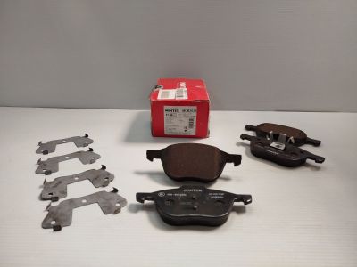 quatre plaquettes de frein et une paire de plaquettes de frein posées sur une table