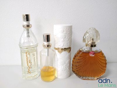un flacon de parfum à côté d'un rouleau de papier toilette et d'un flacon de parfum