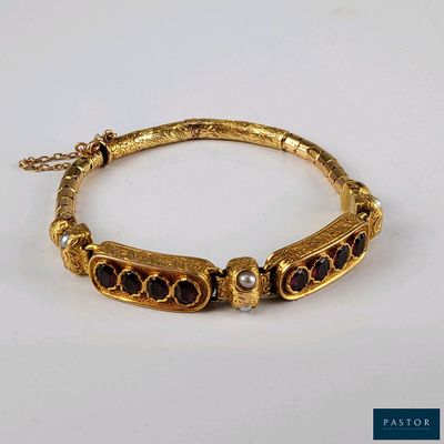 une photo d'un bracelet en or orné de grenats et de perles