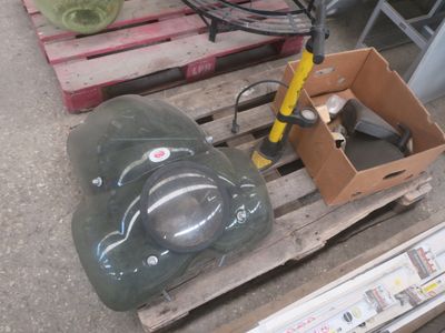 un casque vert posé sur une palette à côté d'une boîte