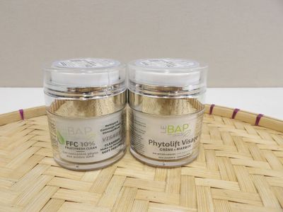 two jars of body scrubs on a wicker tray