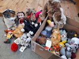 beaucoup de peluches dans une boîte posée par terre