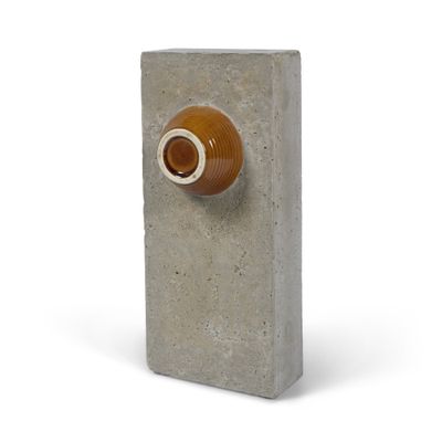 un parpaing orné d'un bouton marron sur fond blanc