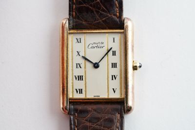 une image d'un gros plan d'une montre-bracelet portant des chiffres romains