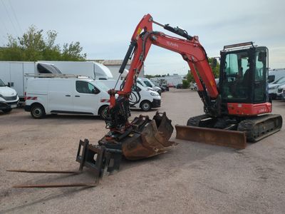 an image of a small excavator in a parking lot