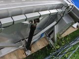 a metal structure with a pipe attached to it in the grass