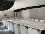 a long table with white chairs in the middle of the room