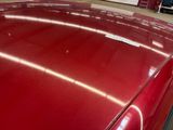 a red car with a sticker on the hood of it