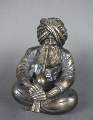 une vieille figurine en bronze représentant un homme barbu coiffé d'un turban