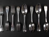 six forks and six spoons arranged in a row on a black surface