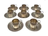 six tasses et soucoupes en métal argenté, posées sur une soucoupe