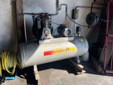 a small air compressor sitting in a garage next to a fire hydrant