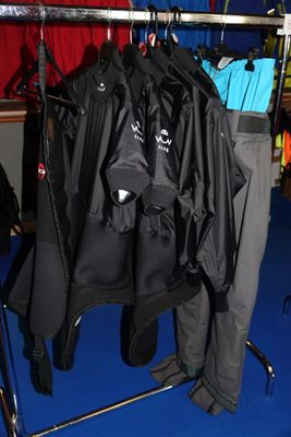 des vêtements suspendus à un portant dans une pièce au sol bleu