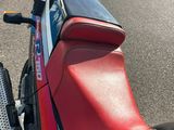 une moto rouge et bleue garée sur le bord de la route