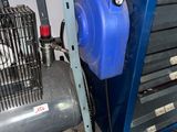 a blue air compressor sitting next to a blue machine