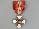 une image représentant une médaille ornée d'un ruban rouge et d'une croix