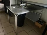 une photo d'une cuisine avec une table et une poubelle