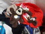 two teddy bears that are sitting on a pile of clothes