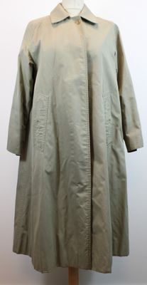 une image d'un manteau de femme sur un support de mannequin