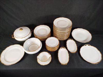 a lot of white and gold plates and bowls on the table