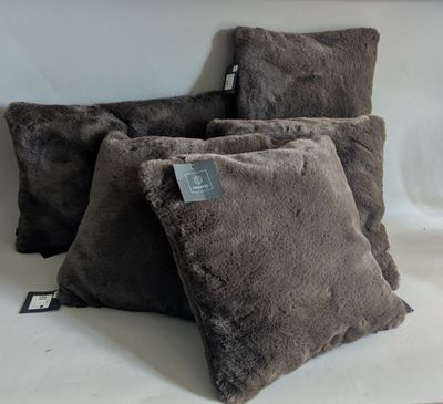 three brown pillows sitting on top of a white table