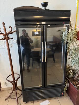 a glass door refrigerator sitting in the corner of a room