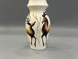 une image représentant un vase blanc orné d'un motif de cerf