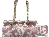 a close up of a pink and white purse with a gold chain