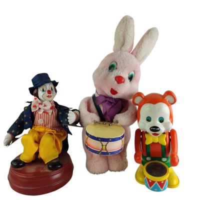 trois figurines de clowns et un lapin avec un tambour