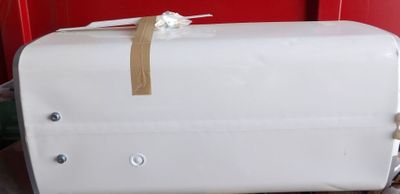 une valise blanche posée sur une chaise rouge