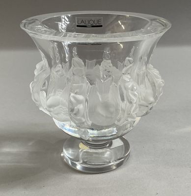 un vase en verre transparent contenant des fleurs, posé sur une table