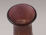 a pink vase with a black rim sitting on a white surface