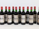 six bottles of wine lined up in a row on a white surface