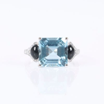 a close up of a ring with a blue topaz and black onyx