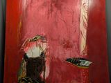paintings on a wall in a room with red walls and white walls