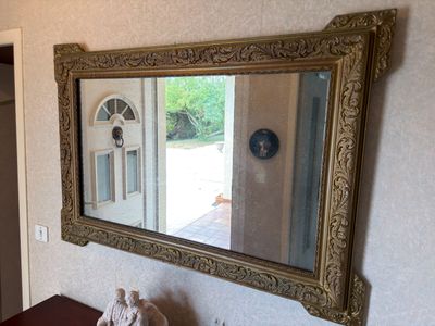 a mirror on the wall above a table with a teddy bear on it