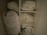 un placard rempli de serviettes et de couvertures blanches