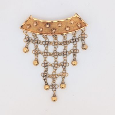 un gros plan d'un collier en or et diamants posé sur une surface blanche