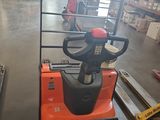 two forklifts in a warehouse with pallets in the background