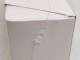 a white box with a necklace on it sitting on a table