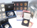 many different types of coins in boxes on the table