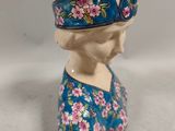 porcelain figurine of a woman wearing a blue dress and a floral headband