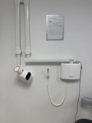 a bathroom with a toilet and a shower head mounted to the wall