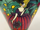 a yellow vase with a picture of a woman on it