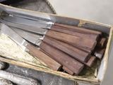 a bunch of knives sitting in a box on a table