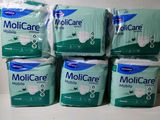 quatre paquets de papier toilette Molicare Mobile empilés les uns sur les autres