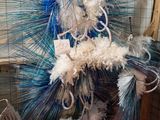 une sculpture en plumes bleues et blanches exposée dans une pièce
