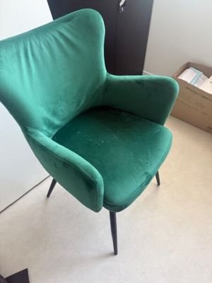 une chaise verte qui se trouve dans un coin de la pièce