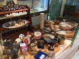 une vitrine remplie d'objets anciens, derrière une paroi en verre
